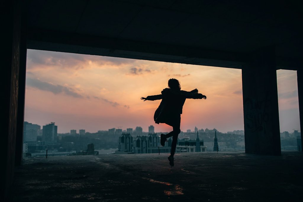 person walking and raising both hands